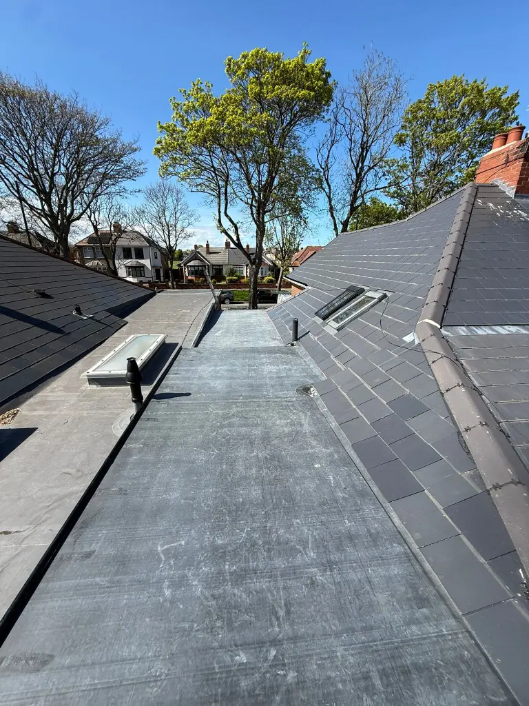 Flat roof section beside a slate roof